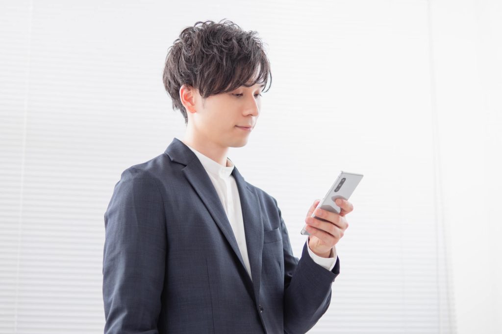 スマートフォンを見るスーツ姿の若い男性